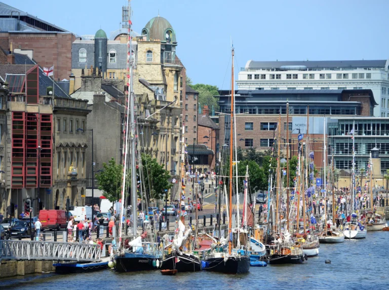 A row of boats parked on the side of the River Tyne